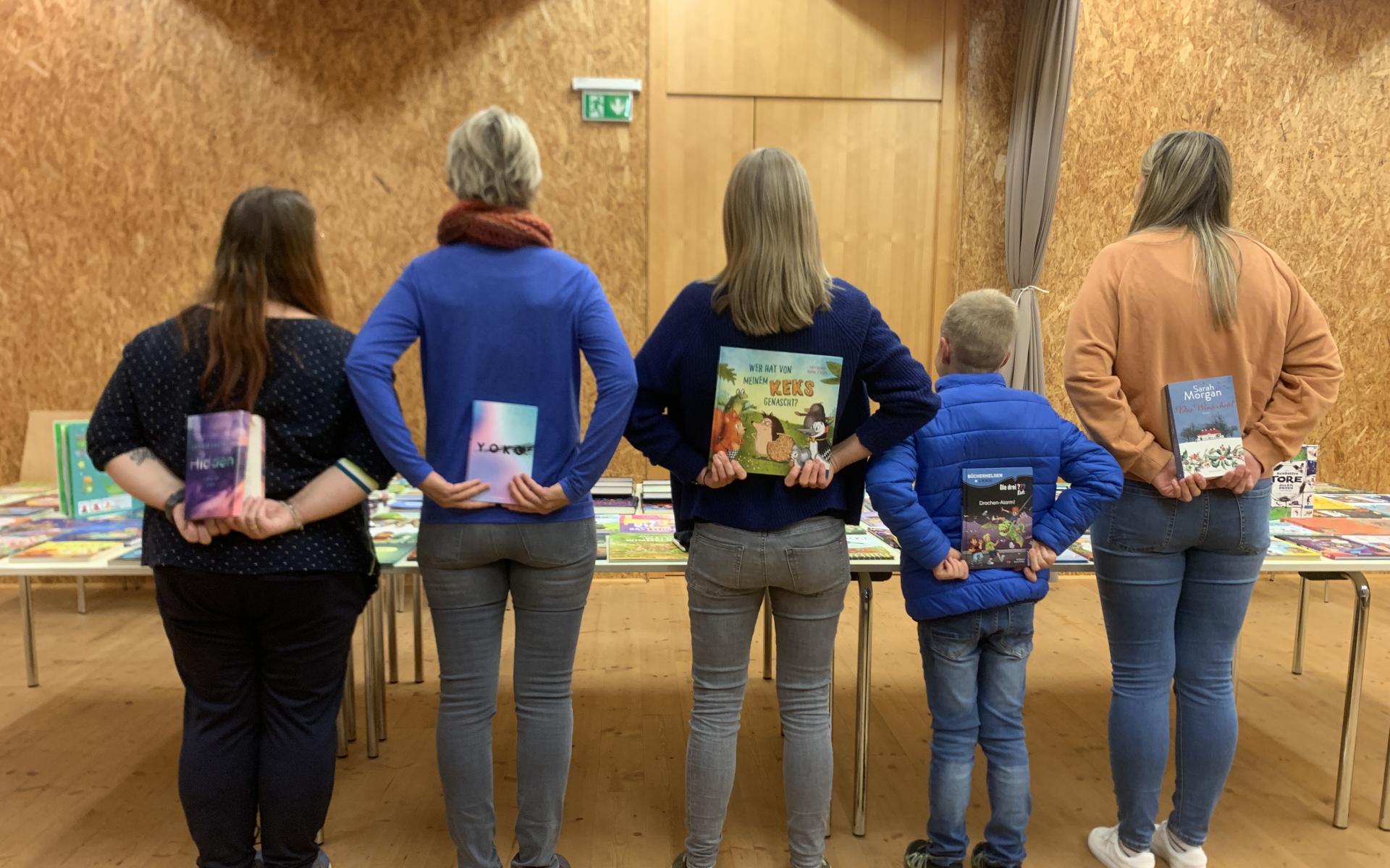 Personen mit dem Rücken in die Kamera ein Buch haltend